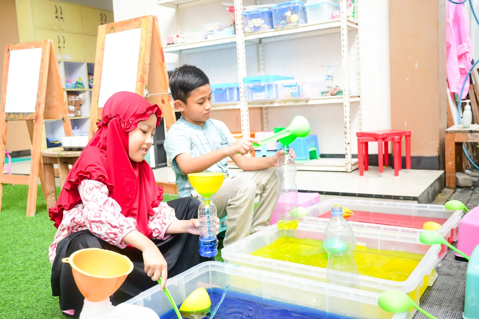 Guru mendampingi eksplorasi anak di sentra bahan alam